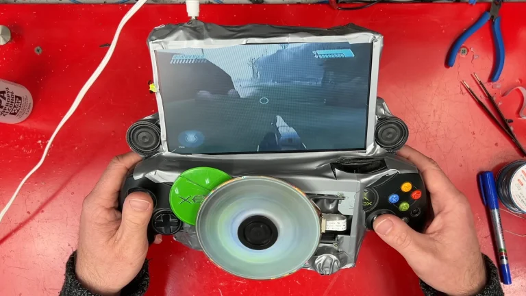 Modder takes hacksaw and hot glue to original Xbox to create a gaming handheld — ‘portable monstrosity’ has exposed spinning DVD in the center and plenty of duct tape, but works as intended | Tom's Hardware