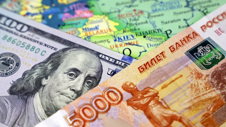 100 dollar bill and 5,000 ruble bill on a map