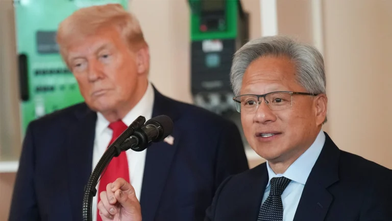 Nvidia CEO Jensen Huang speaking while Donald Trump looks sad in the background.